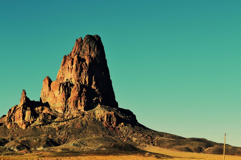 an imposing orange rock tower against a clear evening sky, orange rock tower 4k