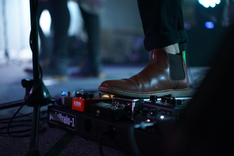 musicians boot steps on guitar pedal near microphone stand, musician steps on pedal 4k