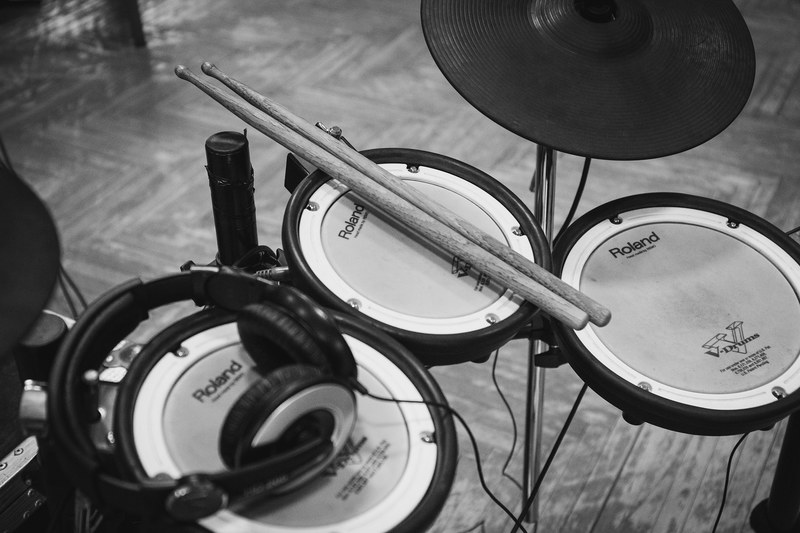 a black and white shot of a roland drumset with headphones and drumsticks, roland drumset in black and white 4k