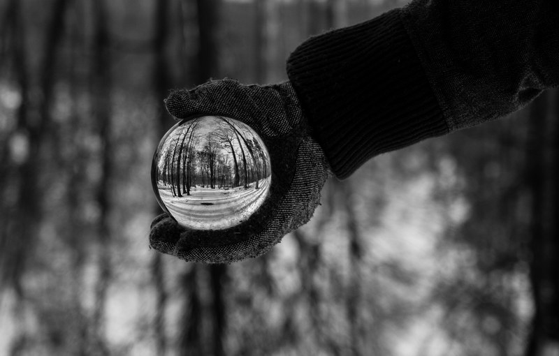 person wearing a glove and a coat holding a crystal ball in black and white, person holding crystal ball 4k