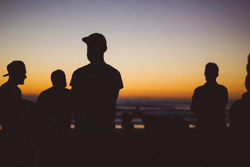 silhouettes of a group of men standing on piha beach during sunset, piha beach silhouettes 4k