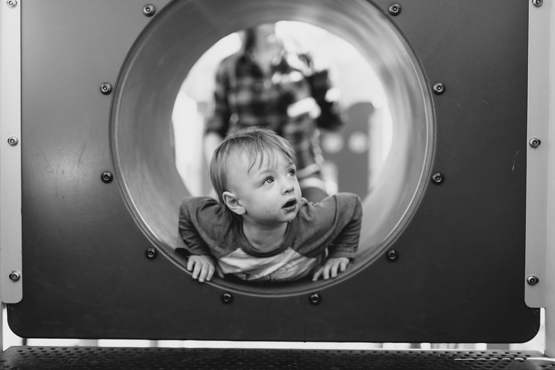 black and white photo of a child going through a tunnel playground in a minneapolis park, minneapolis playground 4k