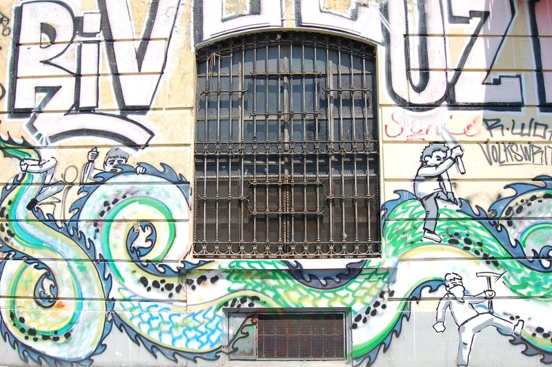 text and snake dragon graffiti on building wall with barred windows, graffiti surrounds building window 4k