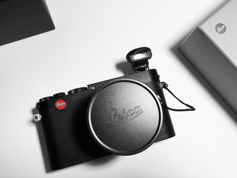 leica camera with log and a flash attachment and lens cap on white table, leica camera and flash 4k
