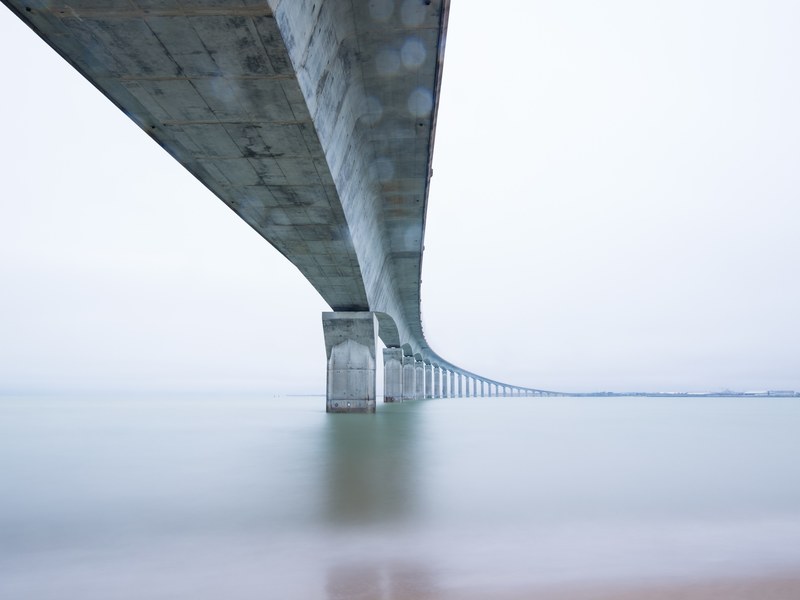 a long curved concrete bridge on a cloudy day, cloudy bridge 4k