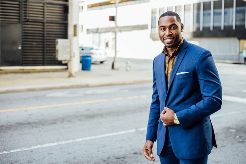 a smiling man in a navy blue suit in an empty street, elegant man in an empty street 4k