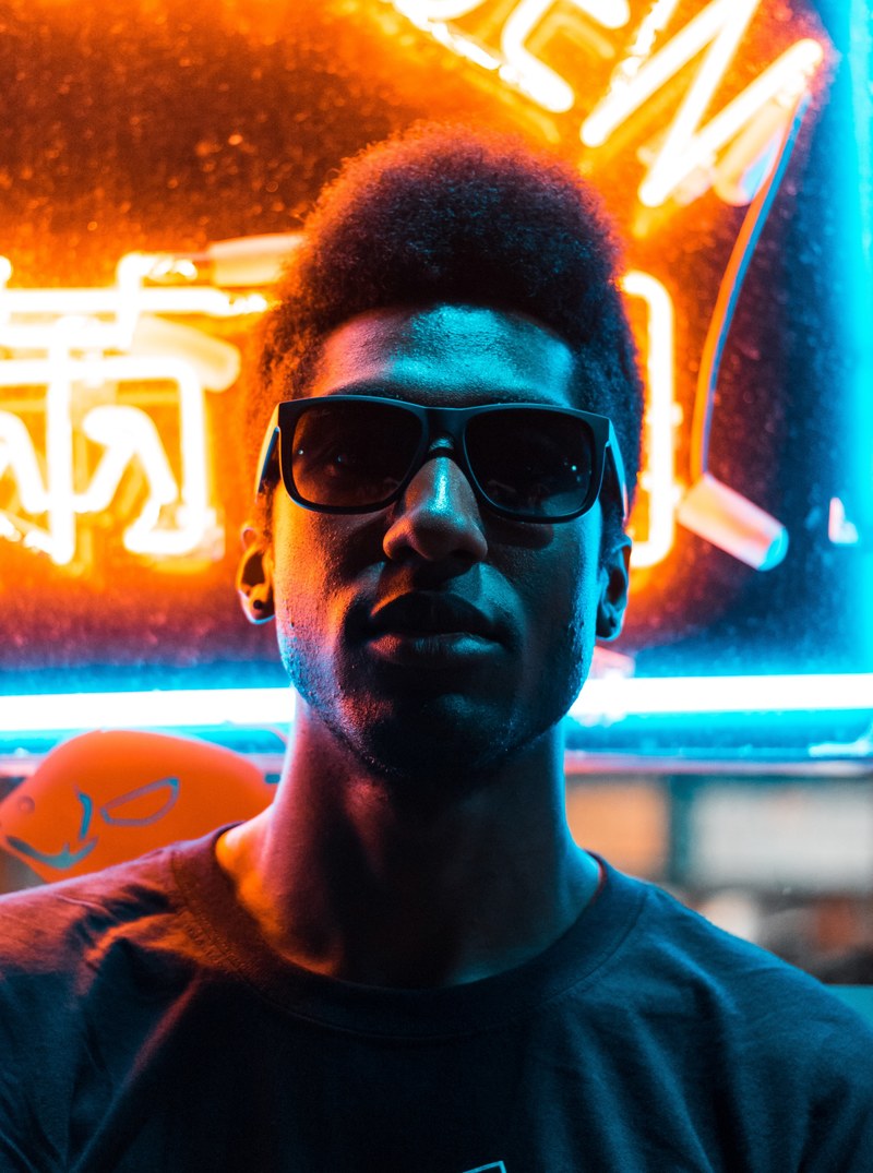 a man in silhouette and sunglasses stands in front of a neon sign in chinatown, relapse 4k