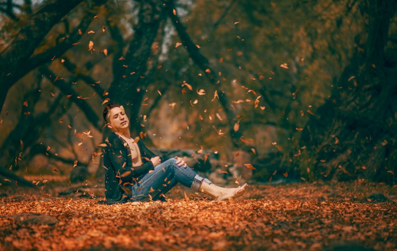 shirtless man in a cardigan sits among falling fall leaves, fall fabulous 4k