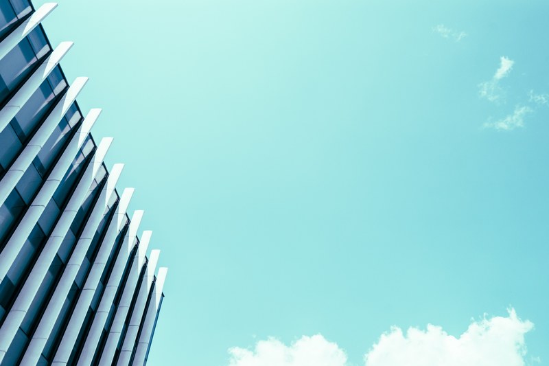looking up at the blue sky next to a building at western university, building western university 4k