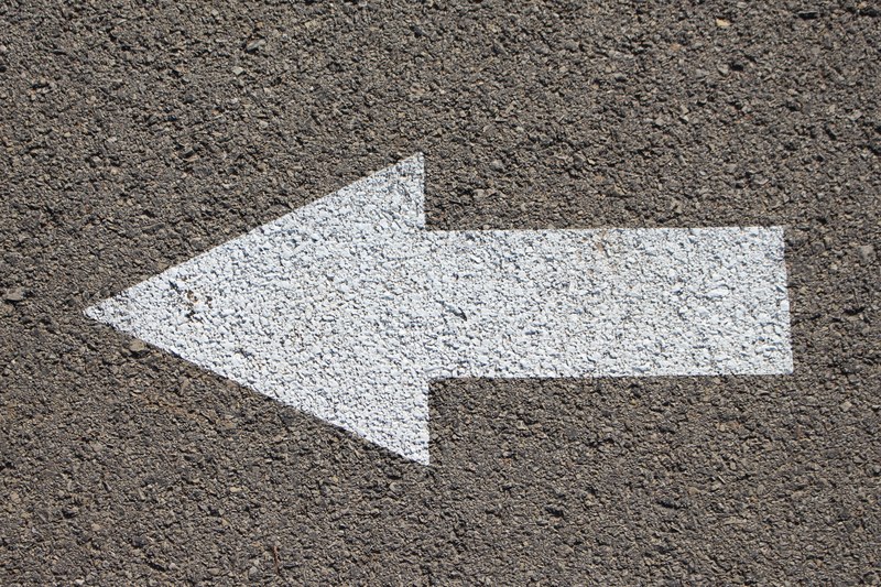 an asphalt road with a white arrow painted on it, arrow in the road 4k