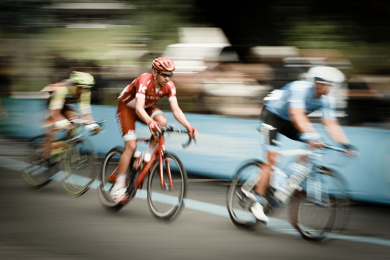 three cyclists travel through metropolitan city of turin in the middle of a bike race, men cycling in turin city 4k