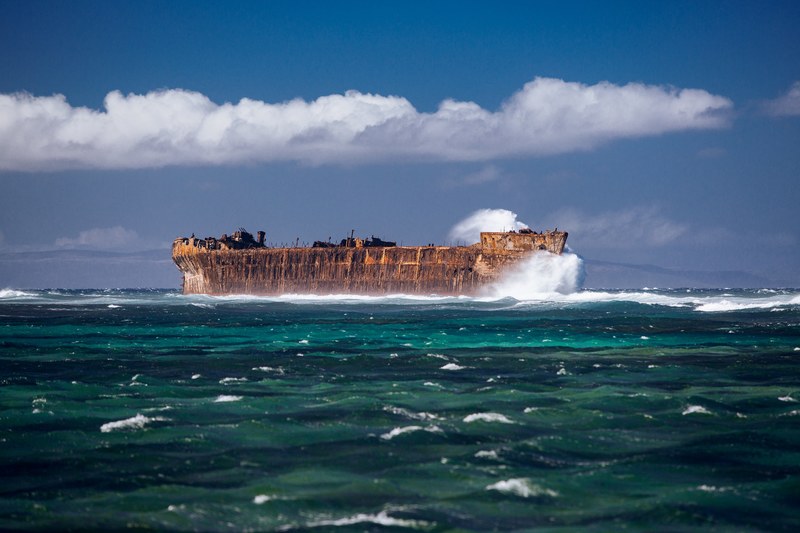 an old rusty ship sailing through the deep green ocean in lanai, rusty ship 4k