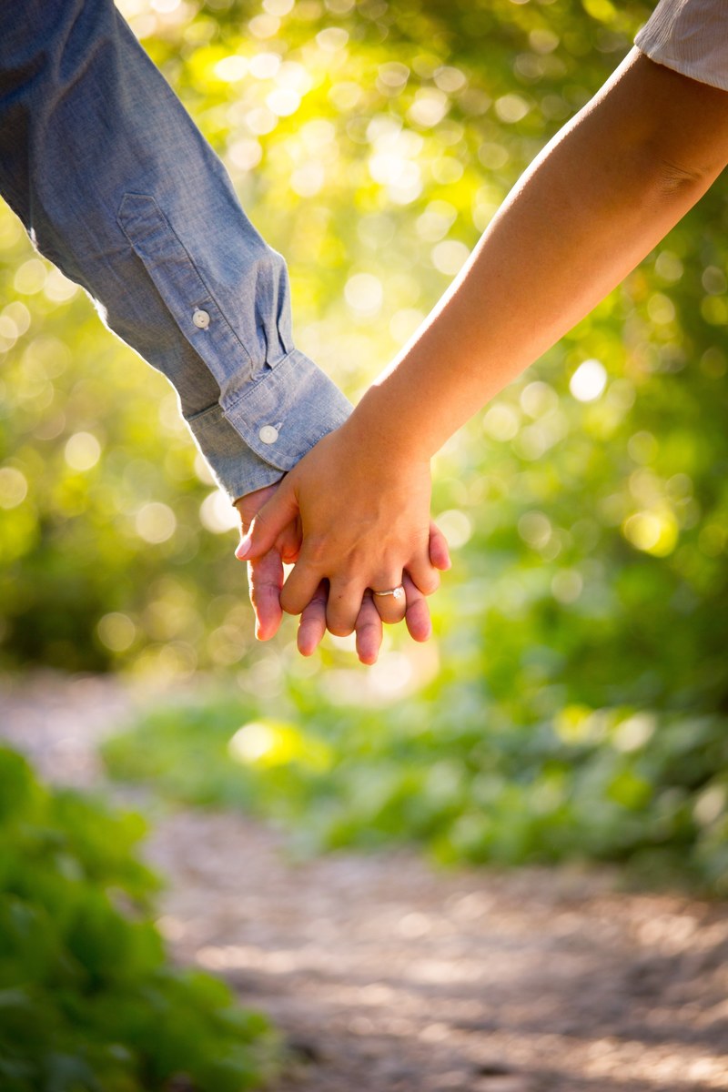 close up of couples interlaced hands on a trail in afternoon, down the trail 4k