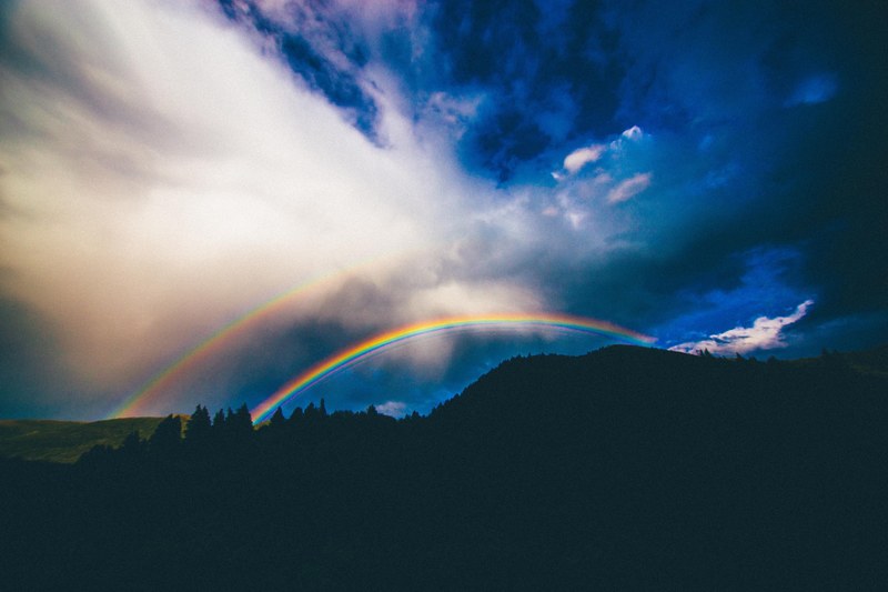a mountain silhouette with a double rainbow in the blue sky in provo, double rainbow provo 4k