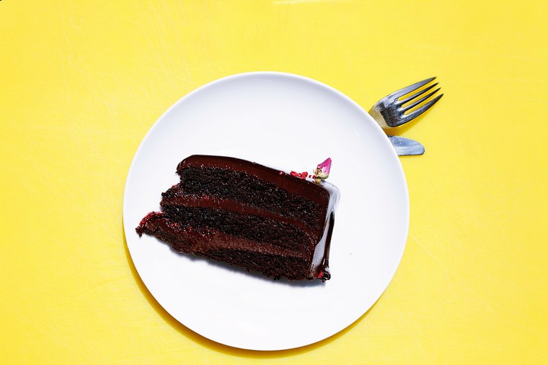 plate of chocolate cake on a yellow background, chocolate cake 4k