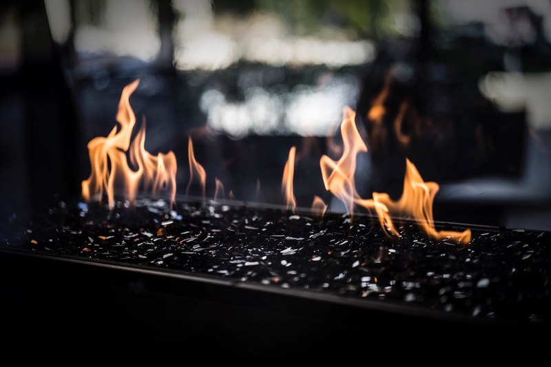 flames of a charcoal stone fireplace on an outdoor patio, unique outdoor fireplace 4k