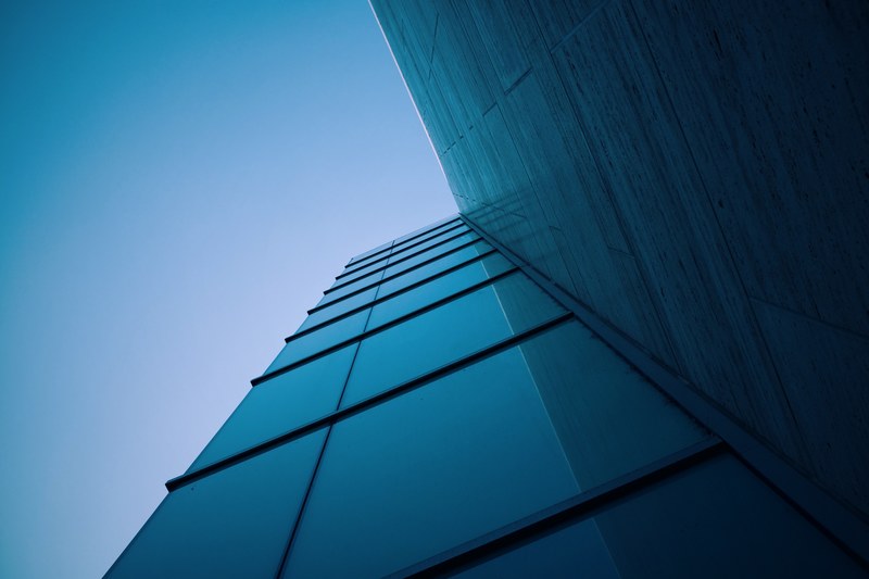 a low angle shot of a corner in a facade of a modern office building, glass building corner 4k