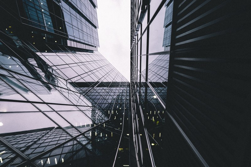 a low angle shot of a reflective office building facade in canary wharf, facade mirror 4k