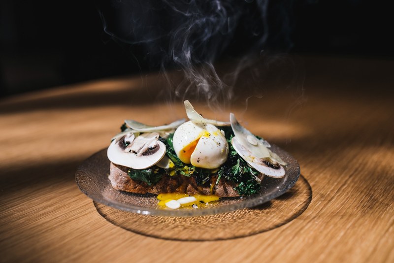 gourmet cafe toast with a steaming poached egg mushrooms and greens, steaming egg meal 4k