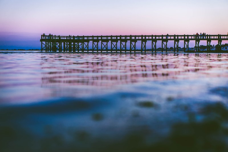 view of the pier after the sunset from the water level at walnut beach, pier at sunset 4k
