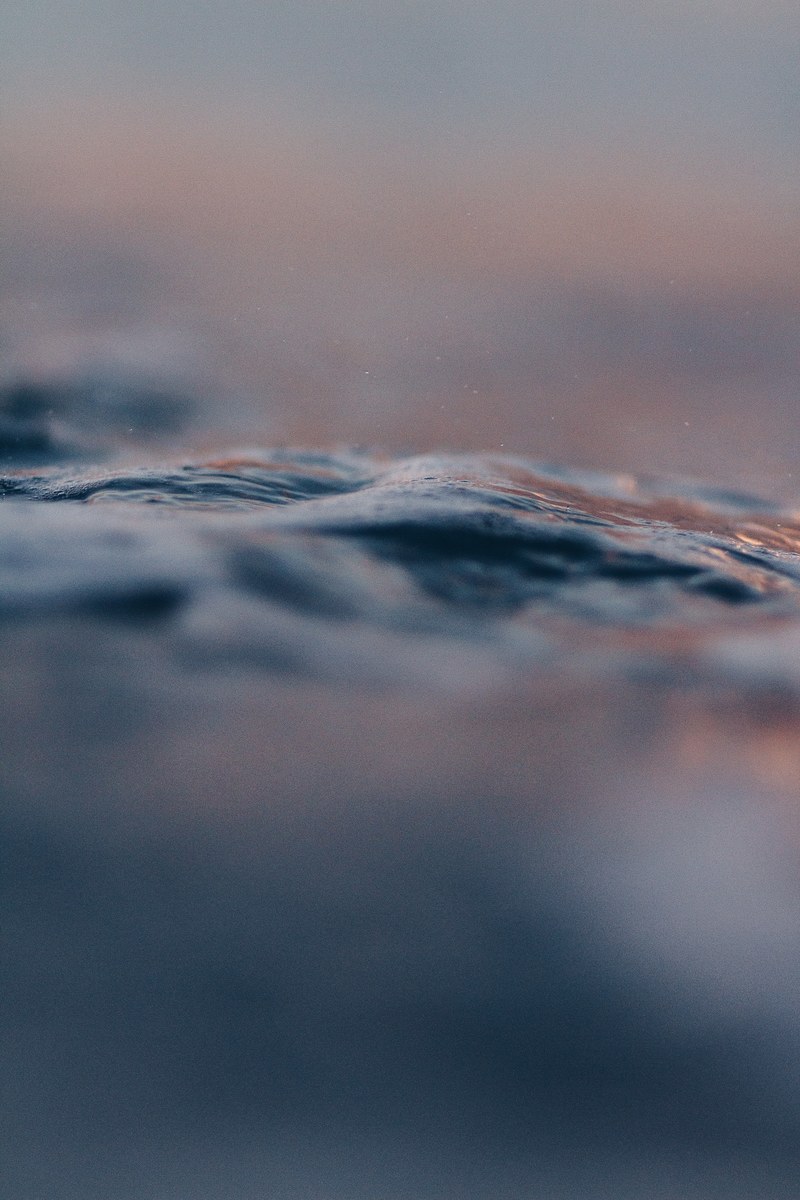 close up of the rough surface of a body of water, sunset mood 4k