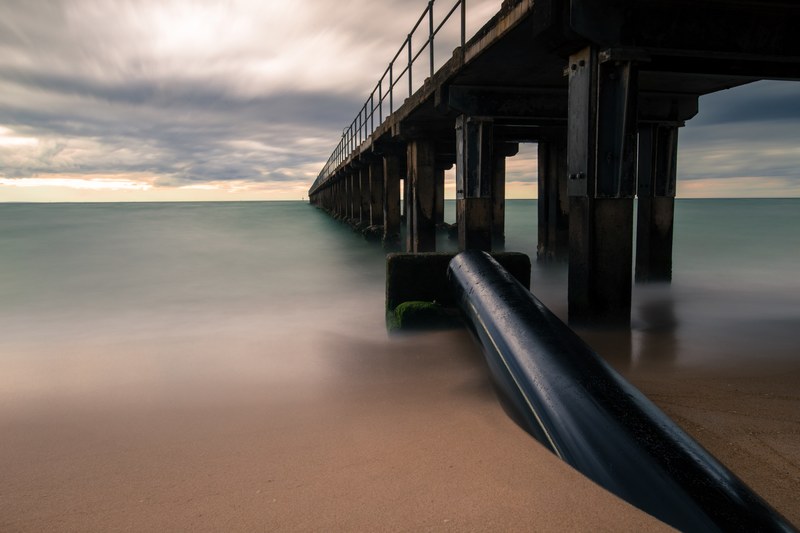 a wooden pier by the ocean in dromana beach during a cloudy sunset, cloudy dromana beach pier 4k