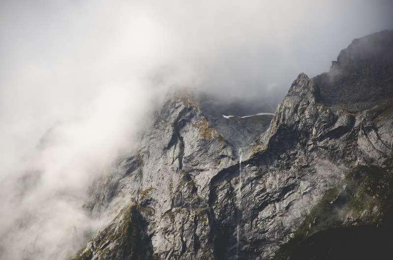 gray rocky mountainside in milford sound, fog on a rocky ridge 4k