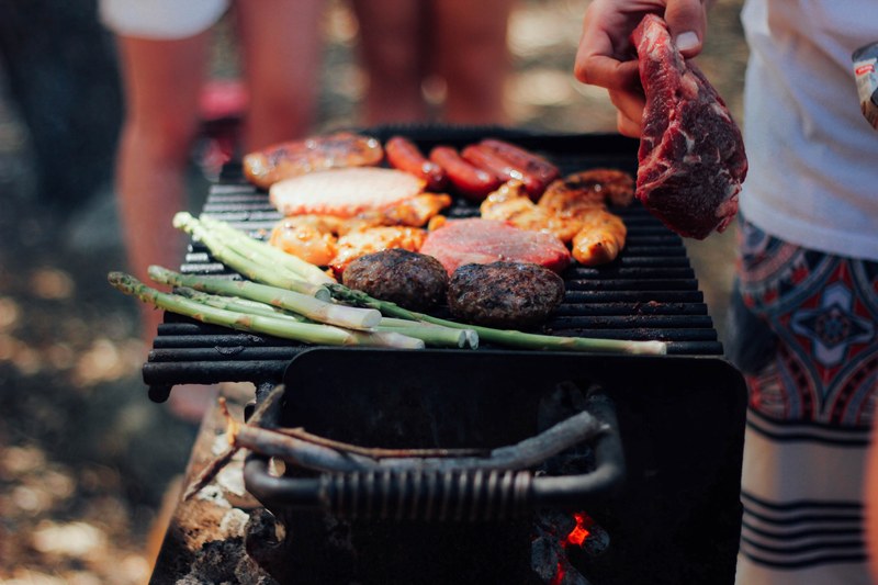 a charcoal grill with meat burgers hot dogs and asparagus at a bbq, bbq meat 4k