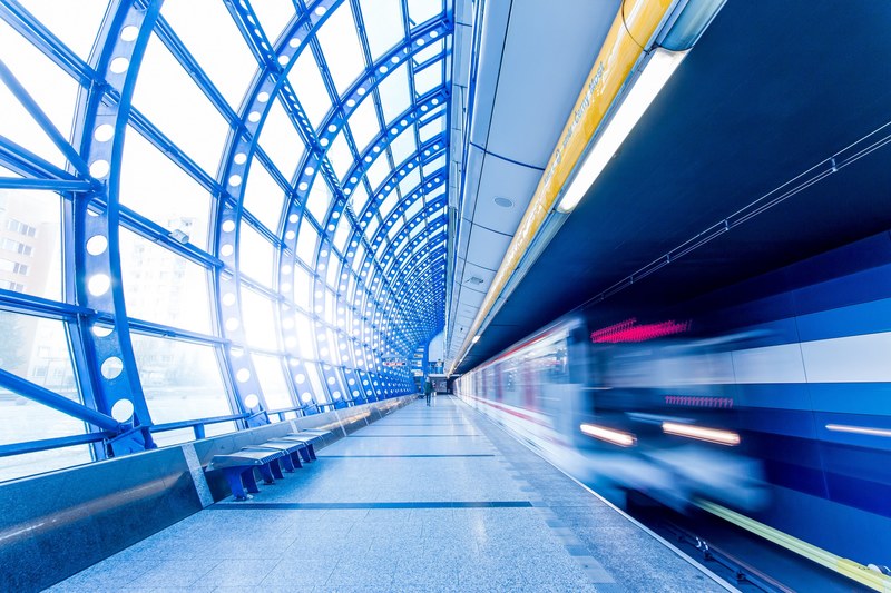 a blurry shot of a train arriving at a railway platform in flint texas, subway train arrives at metro station in motion 4k