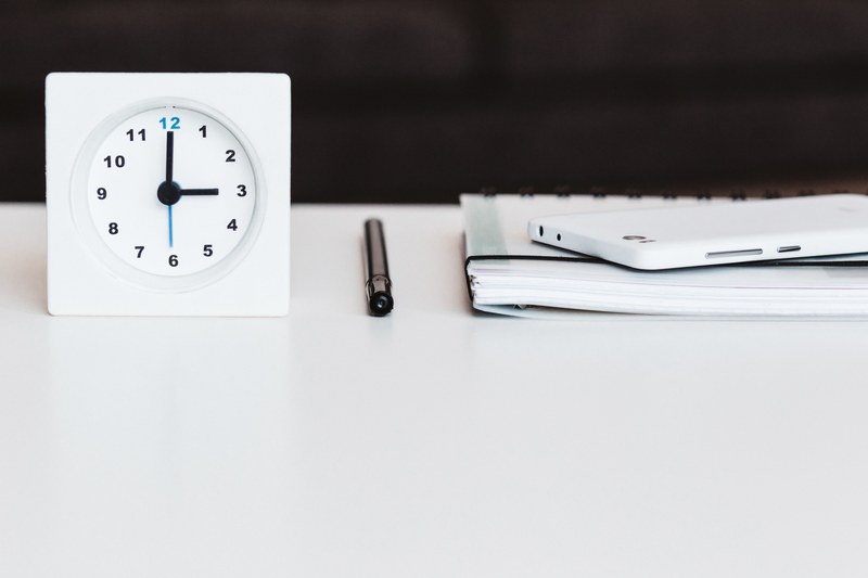 a clock a notebook and a smartphone on a white desk, what time is it 4k