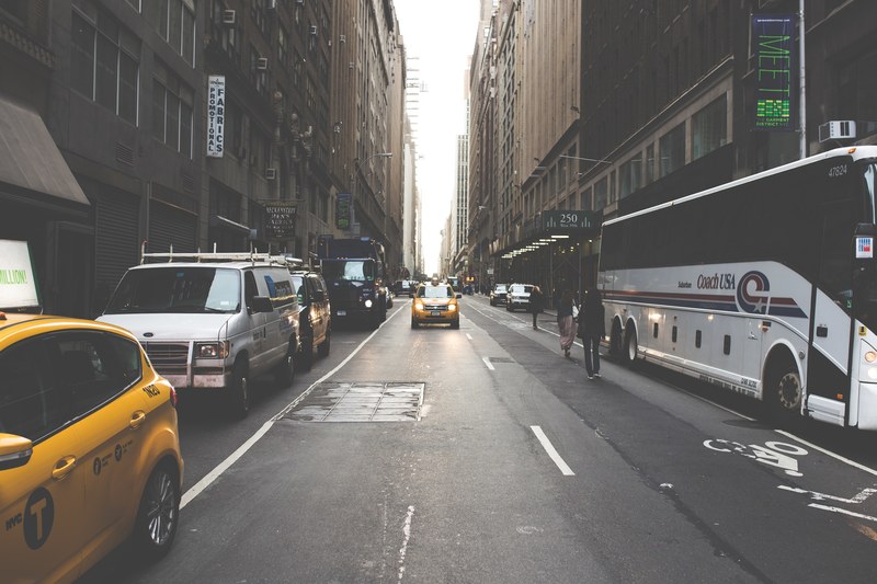 busy urban city street with yellow taxi cab and parked cars and coach, busy street with taxis and parked cars 4k