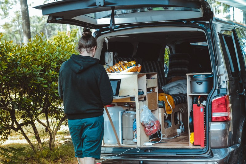 person packs up van with camping gear and supplies, camping supplies 4k