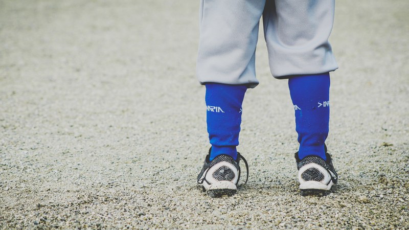 a low shot of a child in sports socks and shoes on gravel, child in sports shoes 4k