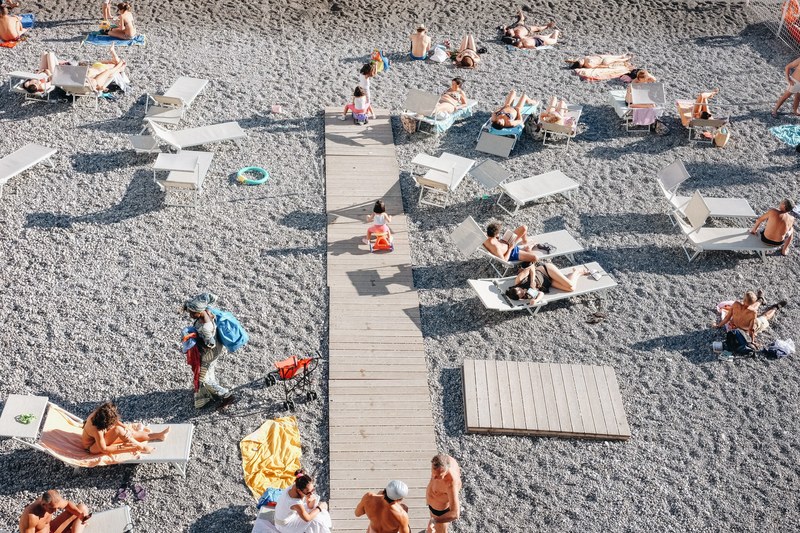 people relaxing on the beach sitting on lounge chairs and enjoying the summer, people on the beach 4k