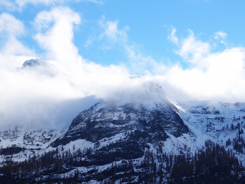a snowy mountain peak enveloped in clouds, clouds around a mountain 4k