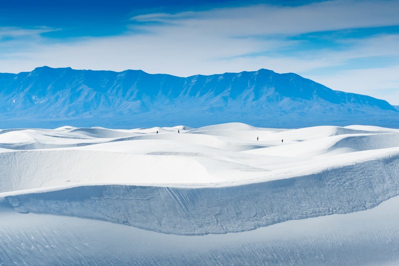 hikers walk through the desert of white sands national monument, white sands and blue mountain 4k