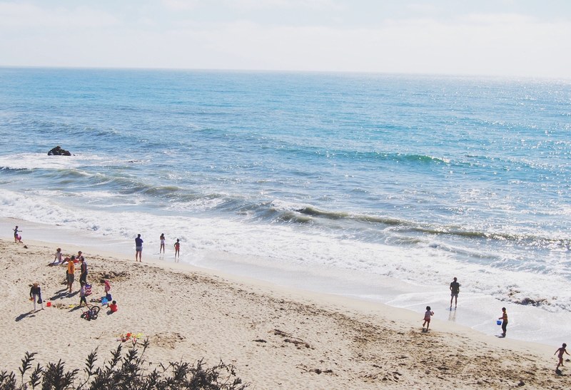 family vacation at the large beach shore and sunbathed ocean, family vacation at beach 4k