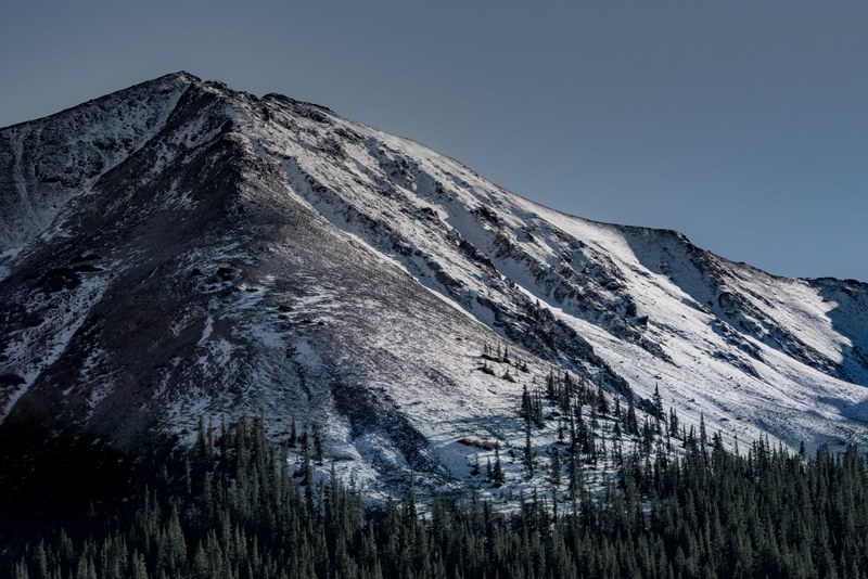 a snow capped mountain in aspen with evergreen woods at its foot, spectacular mountain in aspen 4k