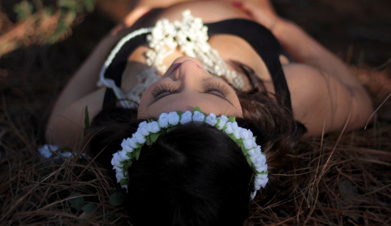 a woman in a floral headband lying in grass, woman with flower headband 4k