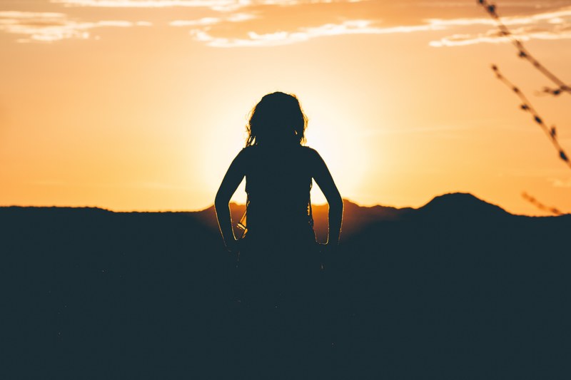 a silhouette of a girl watching the sun set in the distance at the island in the sky, girl watching the sunset 4k