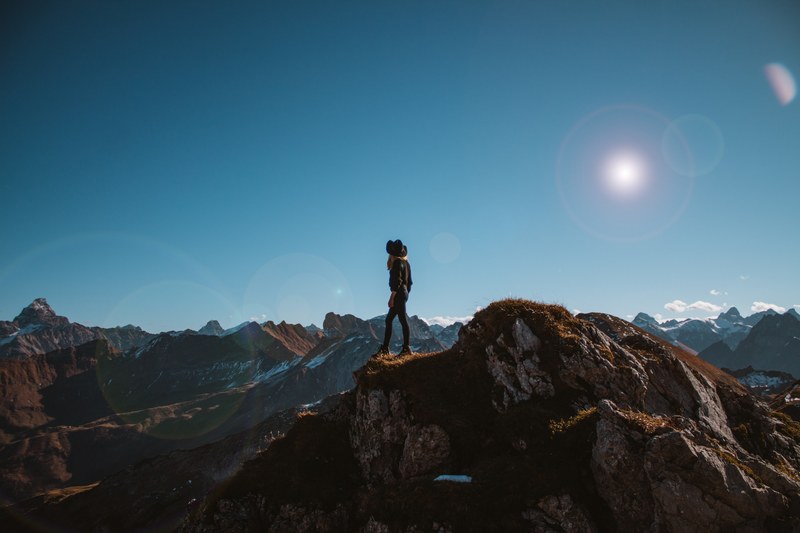 a woman wearing a black hat and black clothing standing on the top of a mountaintop in nebelhorn, nebelhorn hiker 4k
