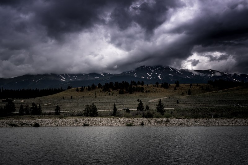 dark storm clouds hover over grassy plains leading to open water, lost in the clouds 4k