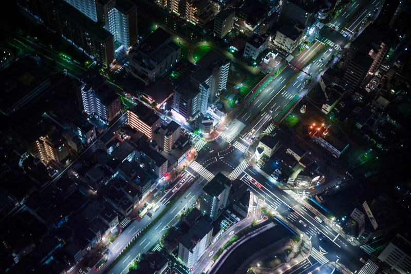 a drone shot of neon soaked streets at night, neon streets 4k