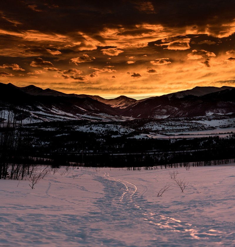 footprints and ski tracks on a snowy slope in silverthorne during sunset, footprints on a silverthorne slope 4k