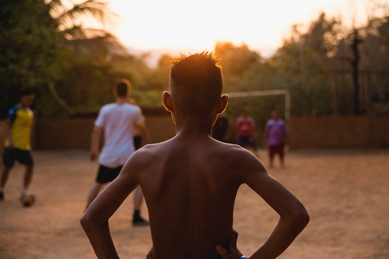 a shirtless african american boy watching a soccer game, _boy watching soccer 4k