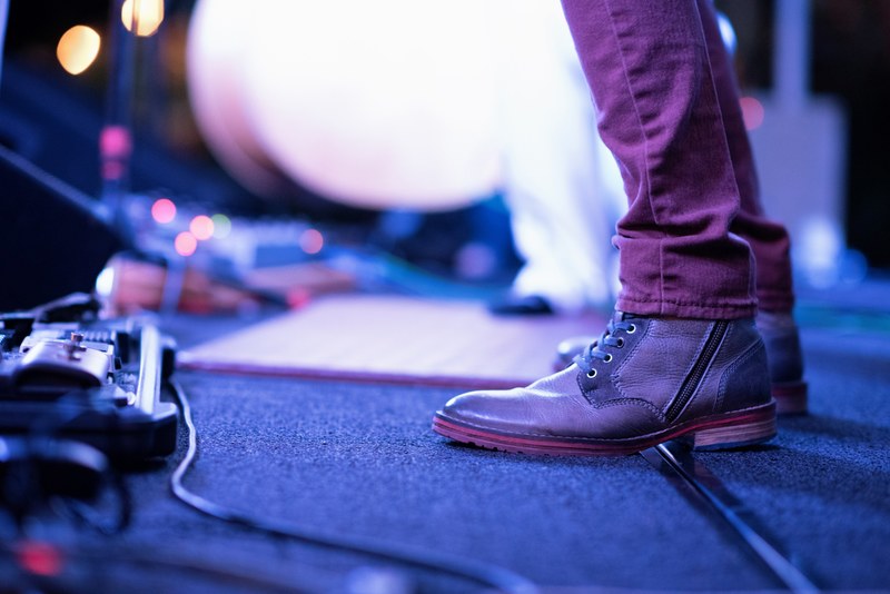 a low shot of the shoes of a person standing on stage, musicians shoes 4k