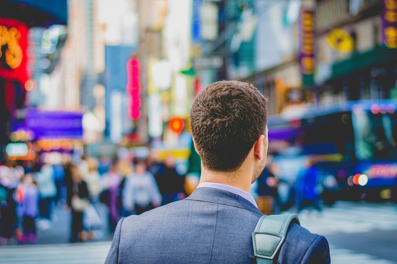 a man with a backpack on the busy times square, at the bustling times square 4k
