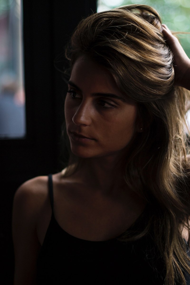 woman sitting in the shadows and thinking, deep in thought 4k