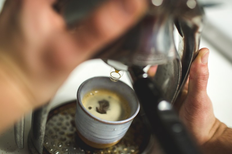 espresso being brewed from an espresso maker and poured into a small clay cup, coffee and espresso 4k