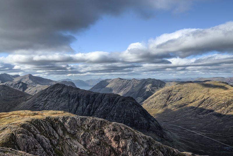 thick clouds moving in the blue sky above rugged mountain ridges in glencoe, cloudy day in the mountains near glencoe 4k